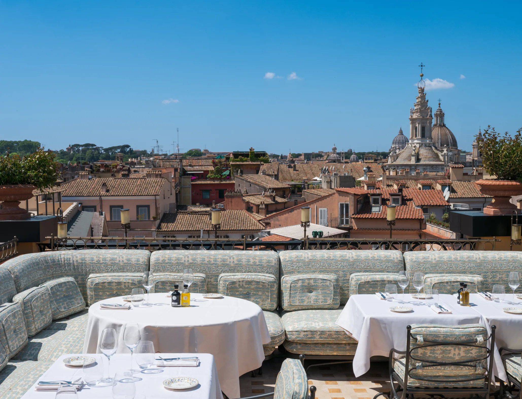GIGI terrasse sur le toit montrant tables nappées blanches face aux toits en terre cuite et dômes de Rome